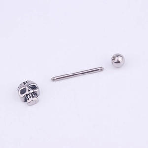 Piercing de langue en acier inoxydable avec crâne et boule sur fond violet