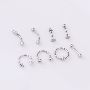 Macro display of 8 stainless steel body piercing studs including eyebrow and lip rings