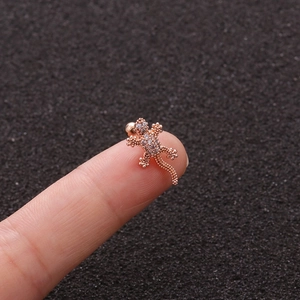 Detailed macro view of a rose gold gecko stud earring with micro-pave zircons on fingertips