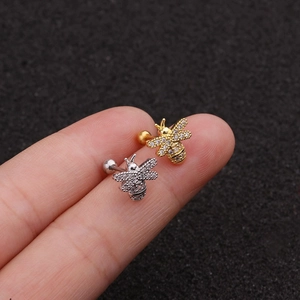 Detailed close-up of mini bee stud earrings with pavé zircons and ball screw back