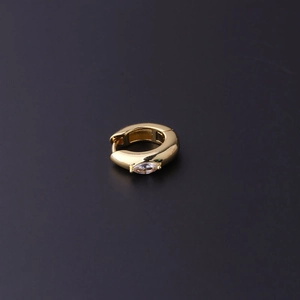 Dettaglio ravvicinato di un orecchino a cerchio placcato oro con zircone a taglio marquise