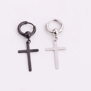 Detail of silver and black stainless steel huggie hoop earrings with cross pendants