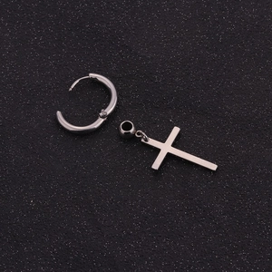 Macro detail of polished stainless steel cross pendant and punk style hoop earring