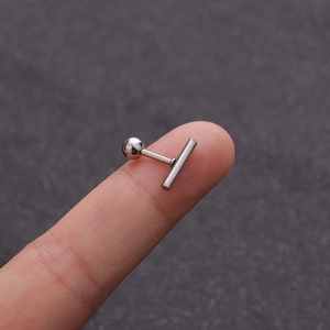Vista macro di un piercing barbell in acciaio inossidabile argento sulla punta del dito
