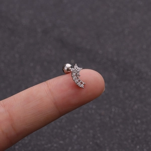 Dettaglio macro del piercing per cartilagine farfalla stella con zirconi e chiusura a sfera