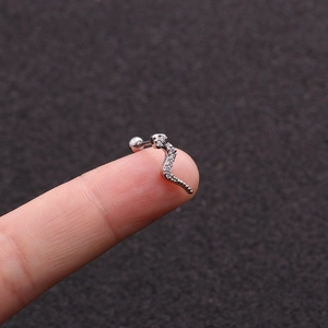 Detailed view of silver snake-shaped stud earring with cubic zirconia on a fingertip