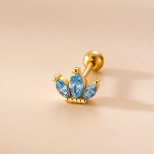 Detailed macro view of a gold crown stud earring featuring blue marquise-cut zircons