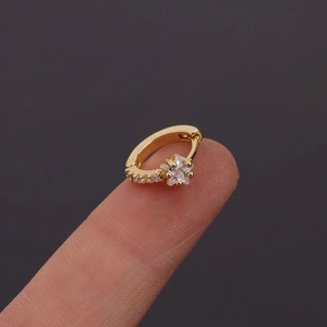 Gros plan détaillé d'une boucle d'oreille huggie étoile dorée ornée de zircons étincelants