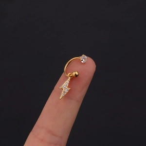 Dettaglio macro dell'orecchino a fulmine placcato oro con pavé di zirconi bianchi