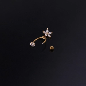 Dettaglio macro di piercing a C dorato con ciondolo a fiore in zircone a taglio marquise