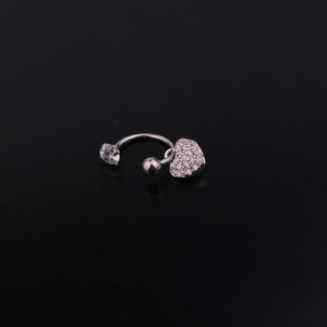 Dettaglio macro di piercing a ferro di cavallo con zircone e ciondolo a cuore lucido