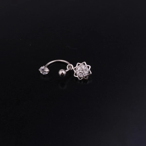 Dettaglio di un piercing a bilanciere curvo in acciaio inossidabile con fiore di zircone