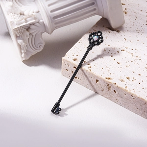 Piercing industrial negro con forma de llave y ópalo sobre fondo de piedra clásica