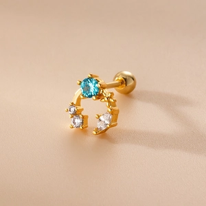 Dettaglio dell'orecchino a vite in oro con zircone blu e accenti a stella