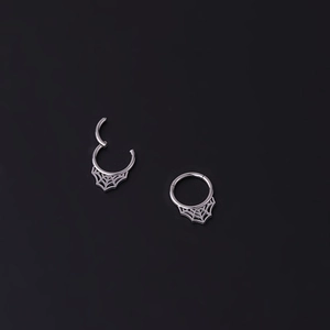 Détail macro d'un anneau de piercing toile d'araignée en acier argenté ouvert et fermé