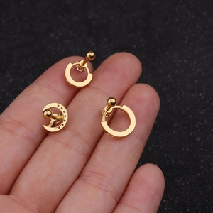 Detailed view of three gold-plated stainless steel helix earrings with cubic zirconia on a finger