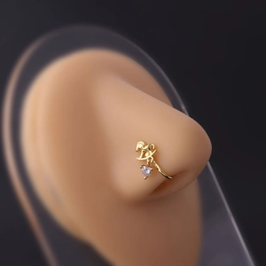 Detail of gold nose clip with rocking horse design and hanging heart zircon on model