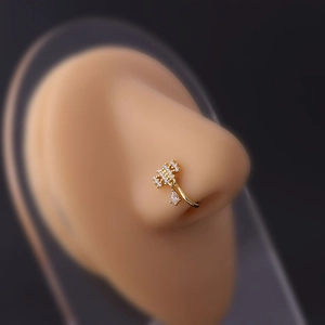 Macro shot of gold floral nose cuff with micro-pave zircons and a teardrop crystal drop
