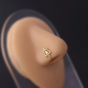 Macro shot of gold-plated nose clip with micro-set zircons on a silicone model