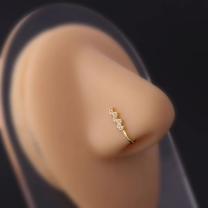 Macro shot of gold-plated lightning bolt nose ring with sparkling cubic zirconia inlay