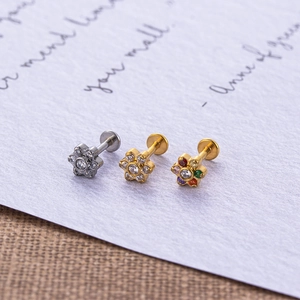 Macro detail of stainless steel flower labret studs with colorful cubic zirconia stones