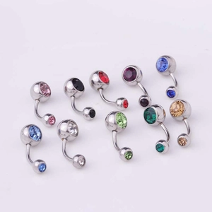 Detailed overhead view of curved stainless steel navel rings with colorful faceted gems