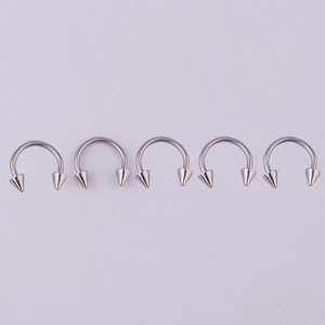 Detailed view of five 316L stainless steel horseshoe rings with spike ends for piercings