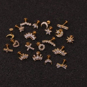 Golden stainless steel crown and heart labret studs with zircons on black background