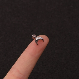 Detailed macro view of silver moon shaped stainless steel flat back piercing stud