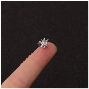 Star shaped stainless steel ear bone stud with zircon stone held on fingertip