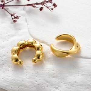 Detail of two-piece gold plated ear cuffs featuring bubble beads and twisted metal designs