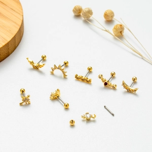 Set of gold stainless steel screw-back ear studs featuring wings and moons with cubic zirconia