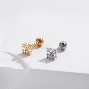 Macro detail of gold and silver cross cartilage studs with cubic zirconia and screw ball back