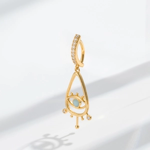 Detail of bohemian gold evil eye navel ring with blue stone and cubic zirconia inlay