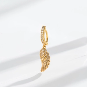 Macro detail of gold angel wing navel ring with crystal pavé and feather texture