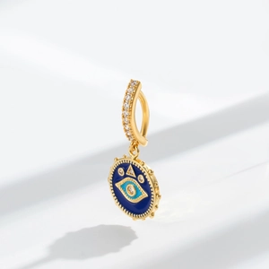 Macro shot of bohemian evil eye navel piercing with blue enamel and sparkling zircons