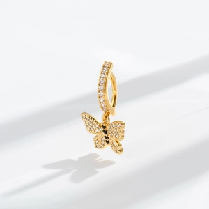 Macro shot of gold butterfly navel ring with inlaid white zircon and black accents