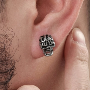 Vintage-Punk-Totenkopf-Ohrstecker aus Edelstahl am Ohrläppchen eines männlichen Models