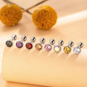 Lot de huit piercings labret en titane F136 avec zircons colorés sur présentoir beige