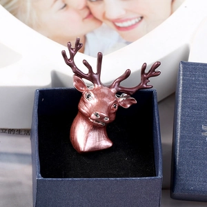 Detailed close-up of a pink stag deer head brooch with rhinestones in a blue gift box