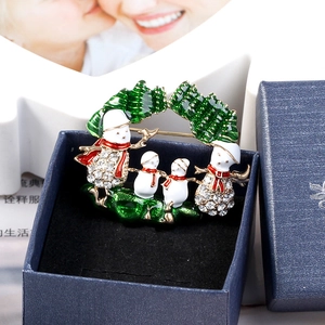 Vue détaillée d'une broche couronne de Noël avec quatre bonhommes de neige en boîte