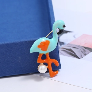 Nahaufnahme einer Flamingo-Brosche mit blauem Emaille und Perle auf Samtbox