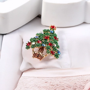 Macro shot of an elegant green beaded Christmas tree brooch with colorful rhinestones
