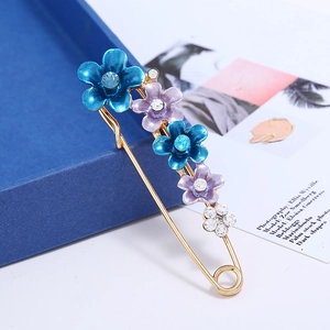 Détail de la broche fleur avec fleurs en émail bleu et centres en cristal brillant