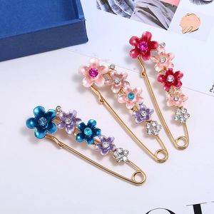 Gros plan de broches florales élégantes avec fleurs en émail et cristaux brillants