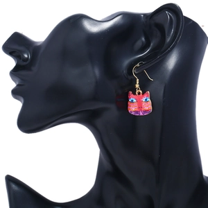 Detailed view of colorful painted cat head drop earring on a black display model