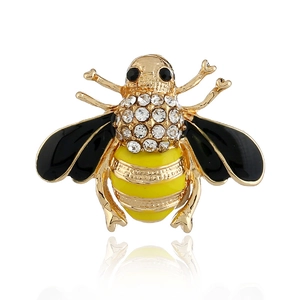Élégante broche abeille dorée ornée de strass brillants et d'émail jaune sur fond blanc