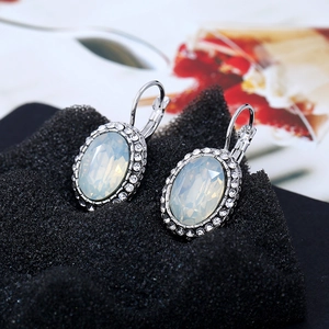 Detail shot of oval opal-style earrings with sparkling rhinestones and silver lever-back hooks