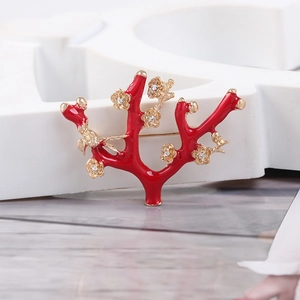 Detail of red coral branch brooch with gold plum blossoms and sparkling crystals