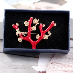 Exquisite red coral crystal plum blossom brooch with gold floral accents in a blue gift box